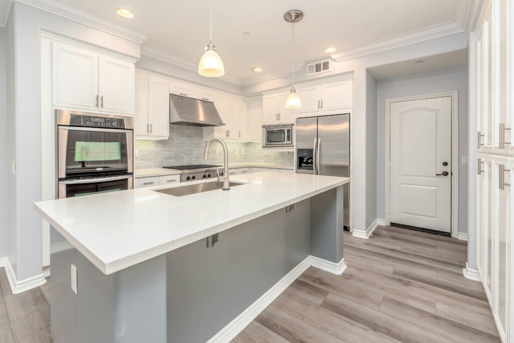 pexels-photo-3623785-3623785 Modern kitchen interior featuring sleek white cabinetry and stainless steel appliances.